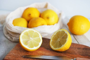 Tahtadaki bütün limonlar hafif arka planda bir bıçağın yanında kesilecek.