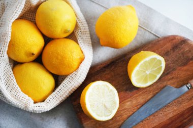 Tahtadaki bütün limonlar hafif arka planda bir bıçağın yanında kesilecek.