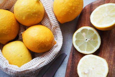 Tahtadaki bütün limonlar hafif arka planda bir bıçağın yanında kesilecek.