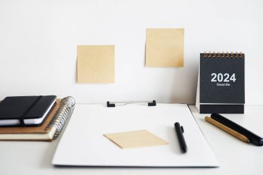 Dizini not defterleri, takvim, çıkartmalar ve beyaz arkaplanda kalemlerin yanına yapıştırın