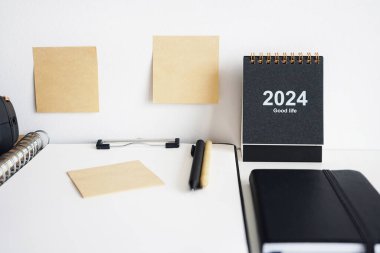 Dizini not defterleri, takvim, çıkartmalar ve beyaz arkaplanda kalemlerin yanına yapıştırın