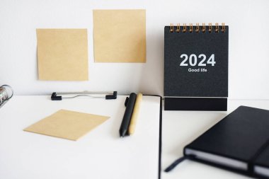 Dizini not defterleri, takvim, çıkartmalar ve beyaz arkaplanda kalemlerin yanına yapıştırın