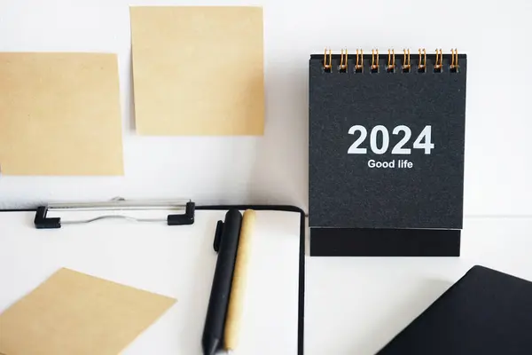 Clip folder with paper next to notepads, calendar, stickers and pens on white background