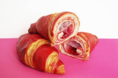 Pembe ve beyaz arka planda ahududu kruvasanları