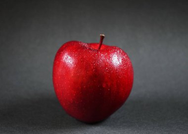 Olgun kırmızı elma, yakın plan, koyu arka plan.