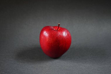 Olgun kırmızı elma, yakın plan, koyu arka plan.