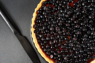 Böğürtlenli turta, arka planda bir bıçağın yanında.