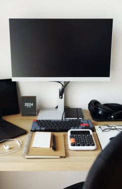Desktop with notepads, laptop, monitor, keyboard, mouse, headphones on a light background clipart