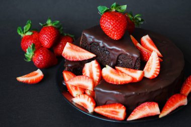 Çikolatalı pasta, kremalı ve koyu arkaplanda taze çilek.