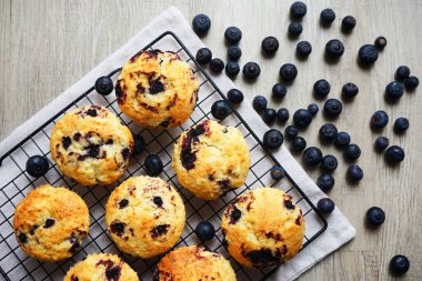 Metal örgü tepside yaban mersinli vanilyalı kek ve gri arka planda yabanmersinli pamuk havlu.