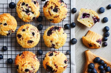 Metal örgü tepside yaban mersinli vanilyalı kek ve gri arka planda yabanmersinli pamuk havlu.