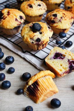 Yaban mersinli vanilyalı çörekler metal ağ tepsisine yakın çekim ve gri arka planda pamuk havlu.