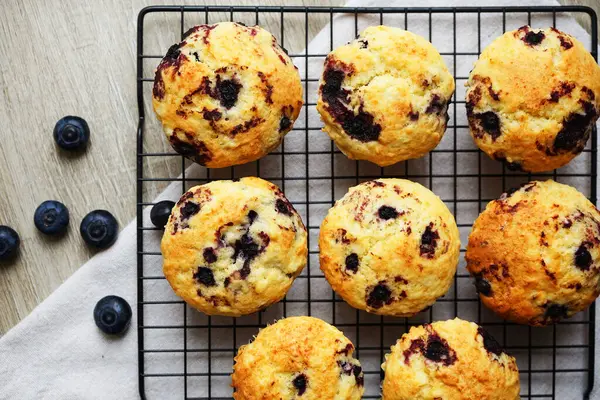 Metal örgü tepside yaban mersinli vanilyalı kek ve gri arka planda yabanmersinli pamuk havlu.