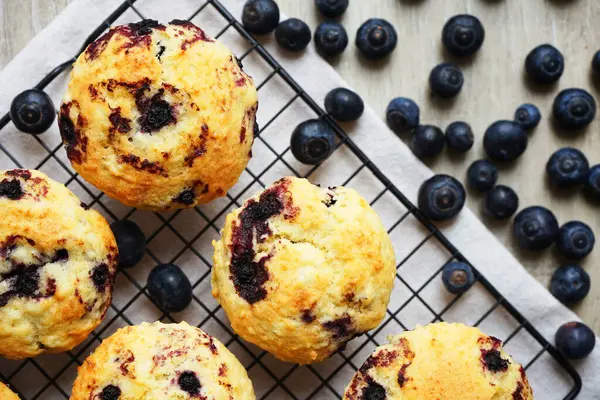 Metal örgü tepside yaban mersinli vanilyalı kek ve gri arka planda yabanmersinli pamuk havlu.