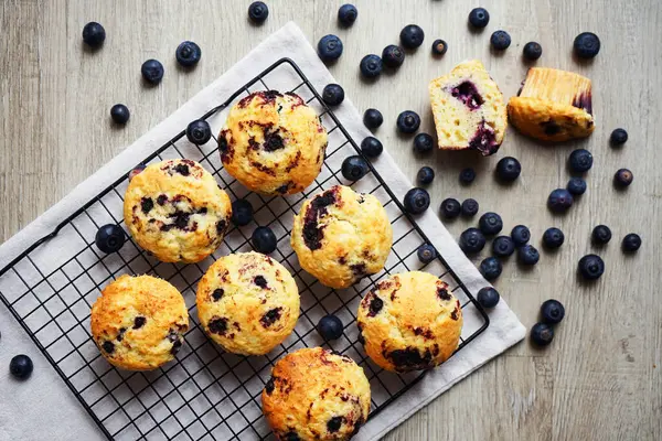 Metal örgü tepside yaban mersinli vanilyalı kek ve gri arka planda yabanmersinli pamuk havlu.