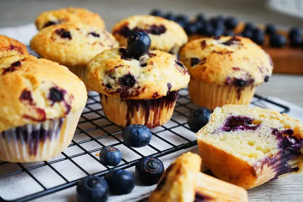 Yaban mersinli vanilyalı çörekler metal ağ tepsisine yakın çekim ve gri arka planda pamuk havlu.