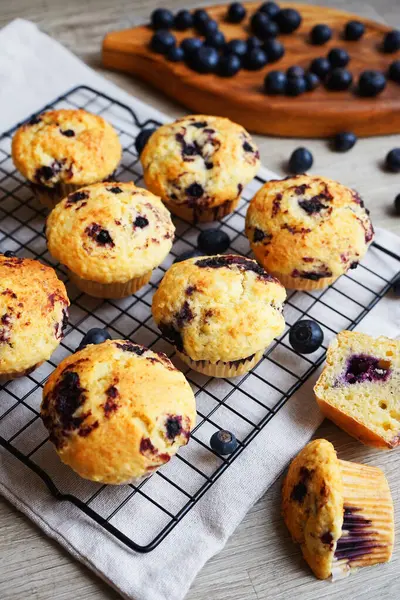 Yaban mersinli vanilyalı çörekler metal ağ tepsisine yakın çekim ve gri arka planda pamuk havlu.