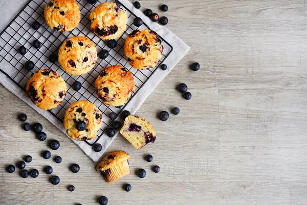 Metal örgü tepside yaban mersinli vanilyalı kek ve gri arka planda yabanmersinli pamuk havlu.