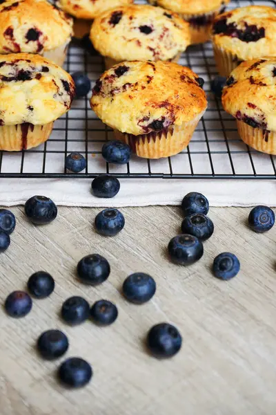 Yaban mersinli vanilyalı çörekler metal ağ tepsisine yakın çekim ve gri arka planda pamuk havlu.