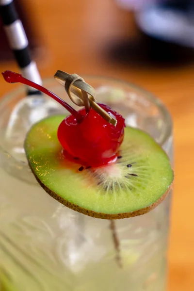 Yeşil yaz kokteyli, kivi ve kirazlı, kamışlı, yakın plan.