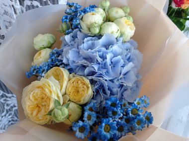 Bayram için bir buket renkli gül, ortanca ve papatya çiçeği sunuldu.