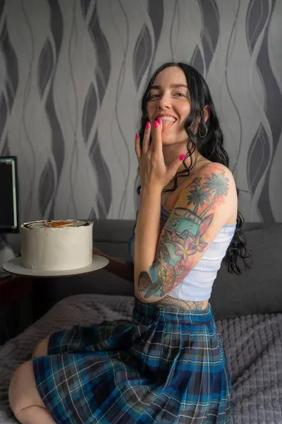 Mutlu mutlu kız doğum gününde bir pasta tutuyor ve parmaklarındaki kremayı yalıyor.