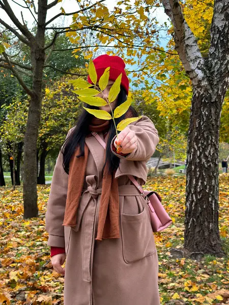 Sonbahar parkında, sararmış Rowan 'ı olan bir kız