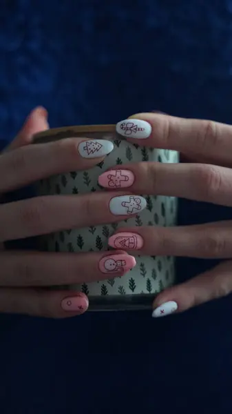 Yılbaşı manikürlü eller Bir mum tutun