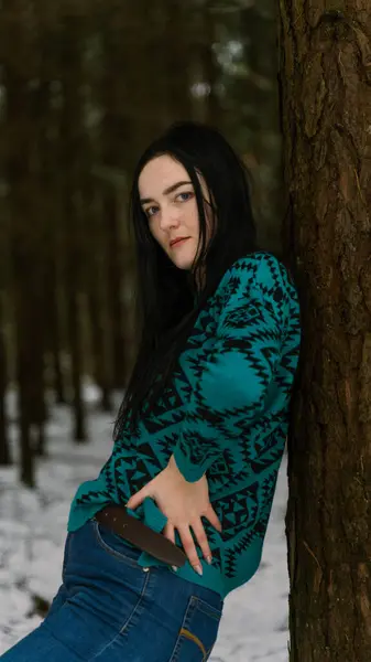 Kış ormanındaki esmer bir kadının portresi.