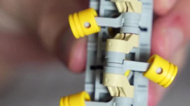 Oyuncağın hareket eden kısmıyla oynayan elin yakın çekimi.