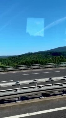 Araba dağlık arazide bir otoyolda gidiyor..