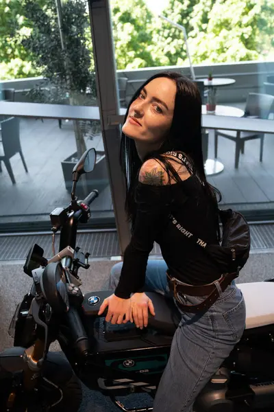 Motosiklette oturan genç kadın.