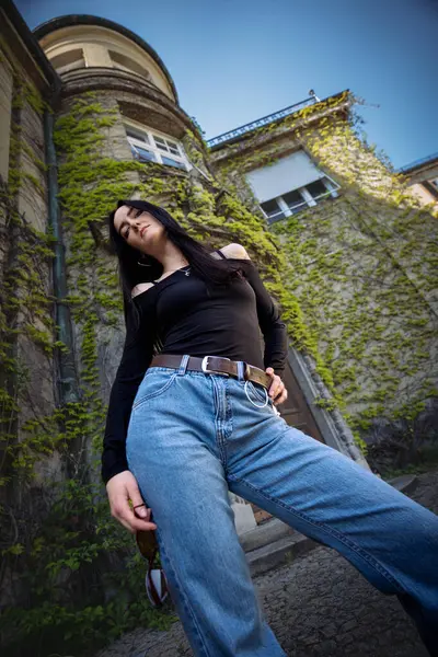 Sarmaşık kaplı binanın önünde poz veren güzel bir kız.