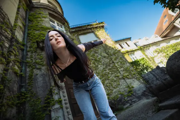 Sokakta şık poz veren kız, şehir tarzı.