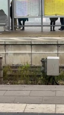 Çocuk tren beklerken istasyonda dans ediyor.