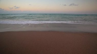 Gün batımında deniz kıyısında dalgaların rahatlatıcı görüntüsü