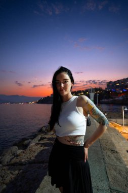 Akşam karanlığında deniz kenarında poz veren kadın