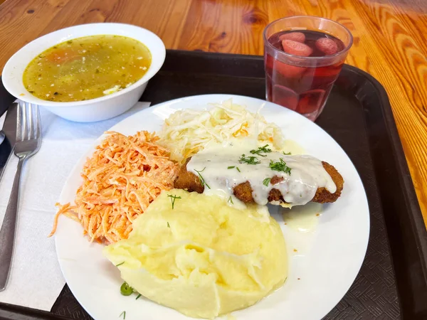 Lunch on tray in the cafeteria. Soup, salad and Schnitzel. High quality photo