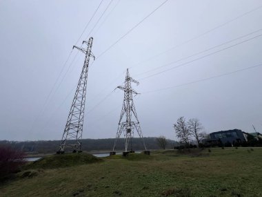 Günbatımında yüksek voltajlı elektrik kulesi Litvanya 'da, kış bulutlu. Yüksek kalite fotoğraf