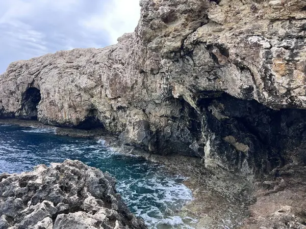 Martinique 'de turkuaz suları ve engebeli uçurumları olan Rocky kıyı mağarası Karayip adasının dramatik doğal manzarasını yakalıyor. Yüksek kalite fotoğraf