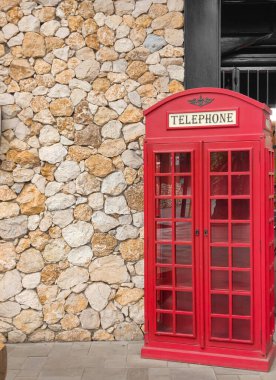 Burası fotoğraf çekmek için kullanılan noktalardan biri, taş desenli bir duvar ve kırmızı telefon minyatür ahşap bir dolap. Kimse yok.