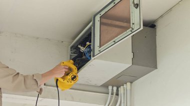 Elektrik sistemlerini hava üfleyiciyle korumak, güvenliği ve verimliliği sağlamak. Bu vitrin teknisyeni elektrik panelini temizlemek için üfleyici kullanıyor..