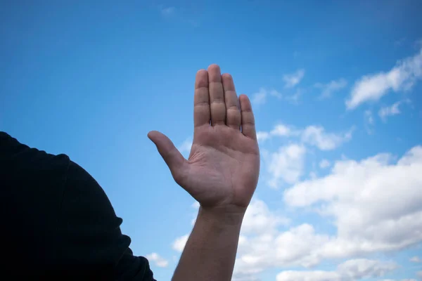 Рука Человека Поворачивается Ладонью Камере Изображена Фоне Голубого Облачного Неба — стоковое фото