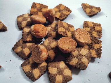 Lezzetli ev yapımı organik tatlı bisküvisinden beyaz zemin üzerinde izole edilmiş bir parça siyah çikolata parçacıklı kurabiye.