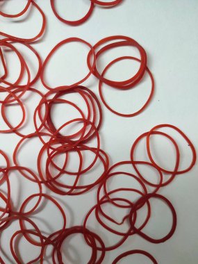 Beyaz arka planda kırmızı lastik bantlar izole edilmiş.