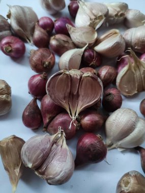 Beyaz arka planda kırmızı soğan ve sarımsak.