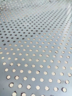 Delinmiş beyaz metal panel arka planı. Noktalı beyaz metal plaka. Alüminyum yumruklama metali