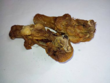 Kızarmış tavuk budu bacağı beyaz arka planda izole edilmiş.