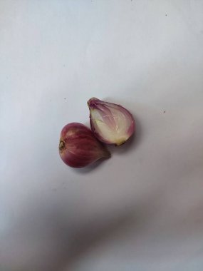 Kırmızı soğan ikiye bölünmüş, beyaz arka planda izole edilmiş.