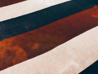 Kirli beyaz, siyah ve kırmızı kumaş altta ve tozla dolu.